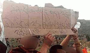 Monks holding a makeshift cardboard banner