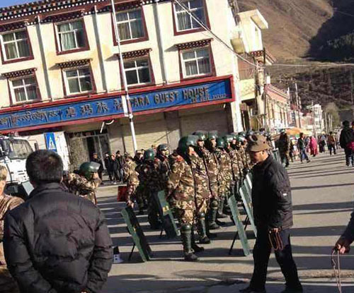 Armed police in riot gear block a road