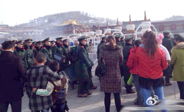 Pilgrims wait for police at the entrance to Kumbum.