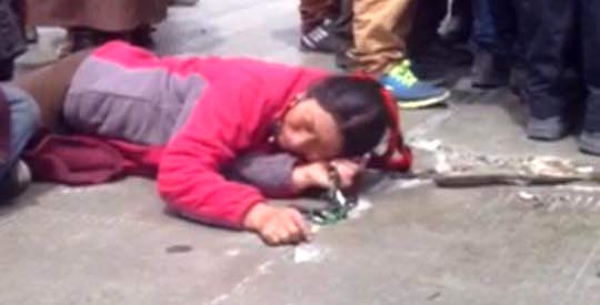 A Tibetan woman lies on the road as part of a sit-in protest at the mine in Lhagang.